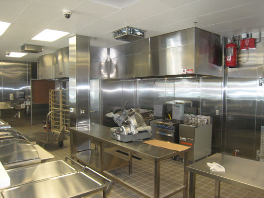 Eye-level view of commercial kitchen hood fire suppression system installed above cooking appliances