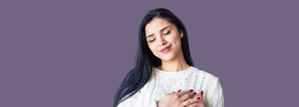 woman in a white shirt holding her hands to her heart