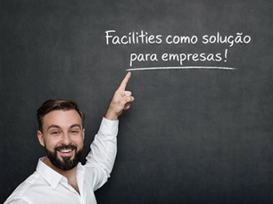 Homem em frente a um quadro negro onde está escrito: Facilities como solução para empresas!