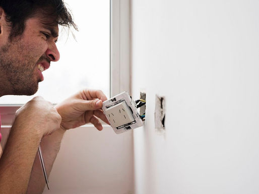 Homem verificando defeito na tomada de casa