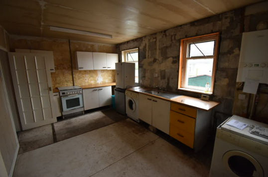 A before picture of an out of fashion, dim kitchen.
