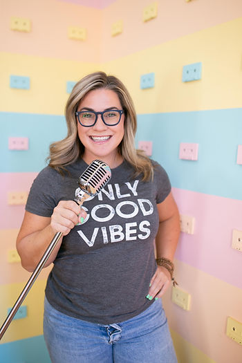 A woman speaking into a microphone with a colourful background