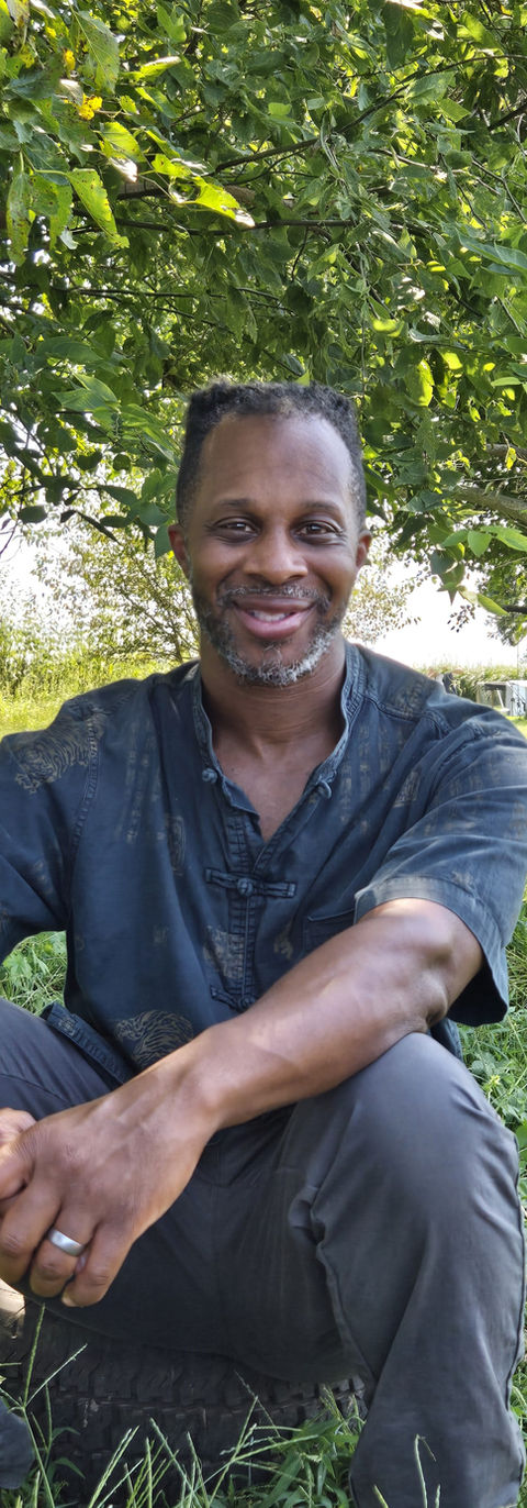 a happy man sits on grass during a nature tour