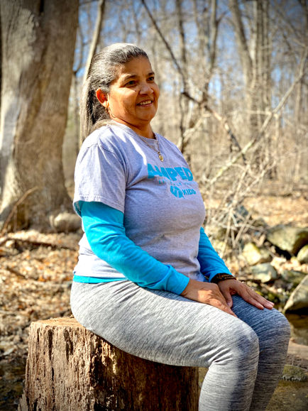Woman sitting on a tree stump outdoors