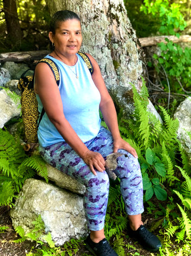 Smiling woman sitting on a rock outdoors