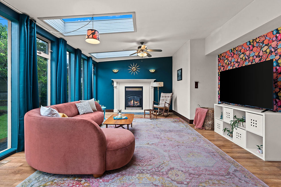 Colorful living room with pink curved sofa, teal curtains, fireplace, skylights, patterned TV wall, and a cozy modern feel
