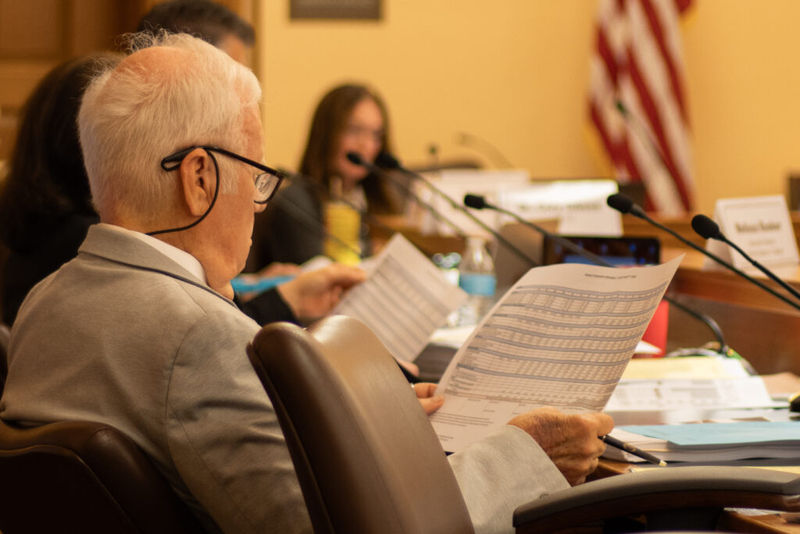 Jim Porter of the Kansas State Board of Education evaluates pages of data at an Education Funding Task Force meeting on May 27, 2026. (Photo by Baya Burgess/Kansas Reflector)