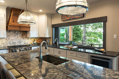 Kitchen serving window connecting indoor space to outdoor deck counter seating