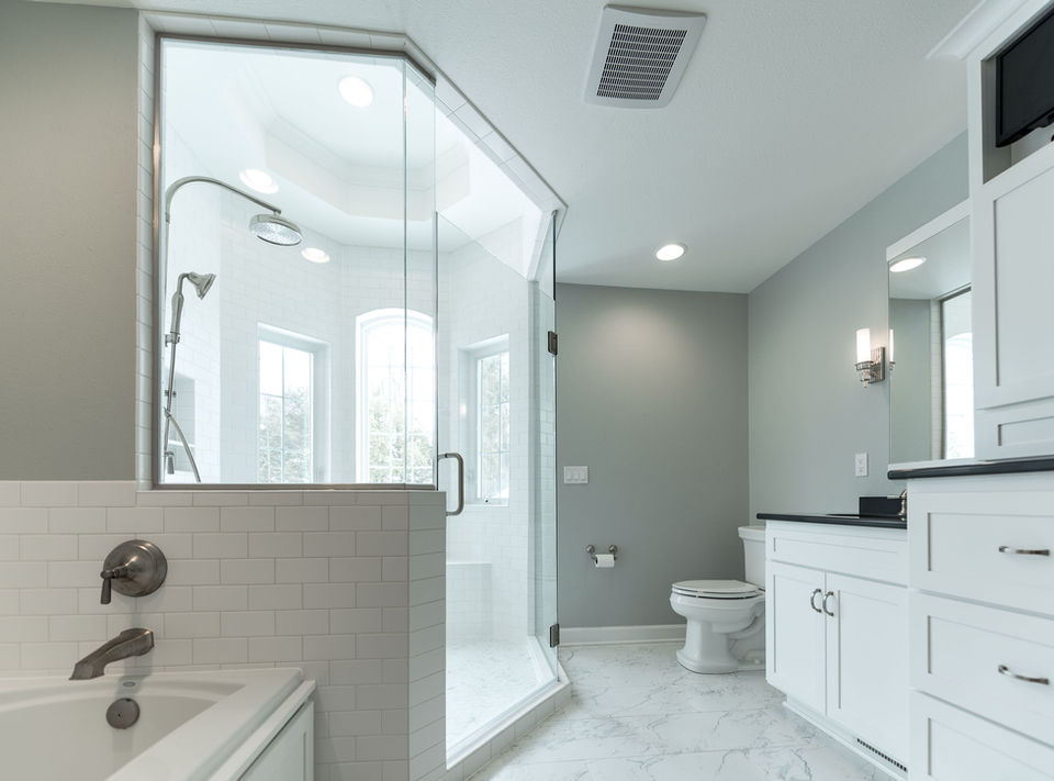 Bathtub with subway tile surround, walk-in hexagon shower, custom cabinetry and marble-textured floor