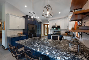 Two-toned kitchen remodel with light upper cabinets, dark lower cabinets and quartz countertops 