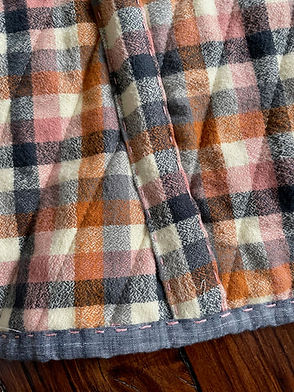 close up image of hand sewn binding covering seams of a quilt coat