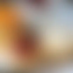 Scones recién horneados servidos con clotted cream y mermelada de fresa sobre una mesa de té tradicional británica.