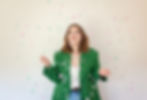 young-woman-wearing-green-jacket-and-jeans-looking-up-at-confetti-at-brand-photoshoot-in-s