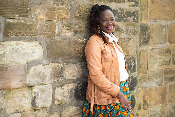 woman-wearing-brown-leather-jacket-standing-against-stone-wall-in-aberdeen-at-branding-pho