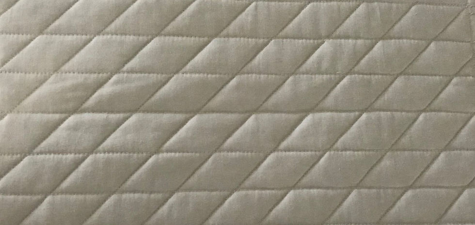 Parallel machine quilting pattern of horizontal lines and diagonal lines combined.