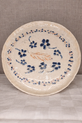 Assiette en grès blanc réalisée à la plaque avec des décors gravés sur pièce crue et décoration à l'engobe