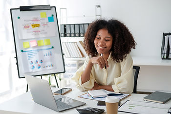 Black woman with fro sitting at desk looking at computer