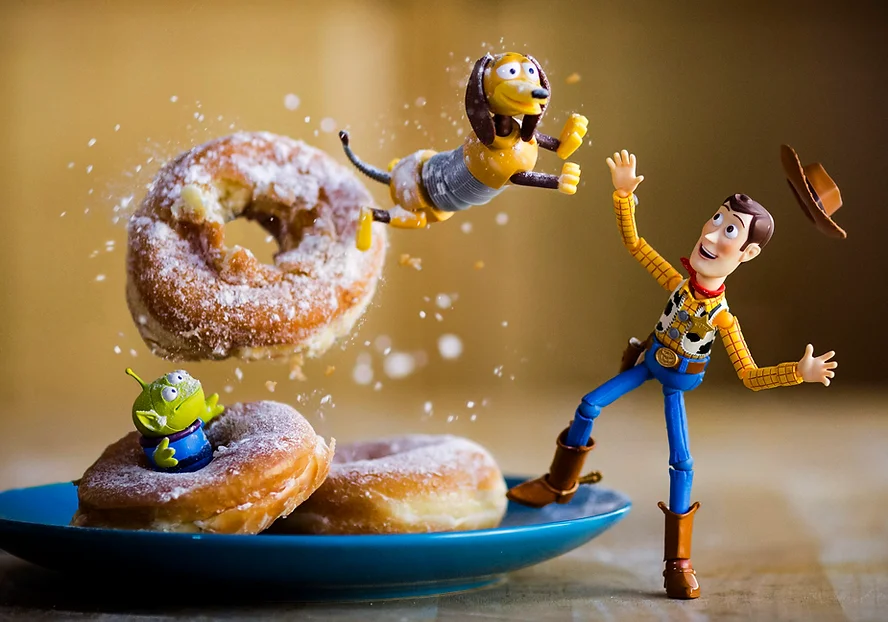 Toy Story Slinky Dog jumps through an airborne donut while Woody looks on