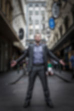 Full-length personal branding portrait of a man standing in a city laneway.
