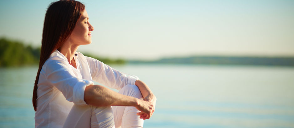 Mulher meditando em frente ao rio