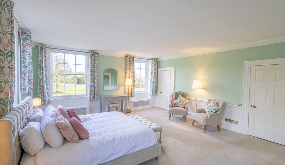 The master bedroom view of the super king bed, windows and dressing table