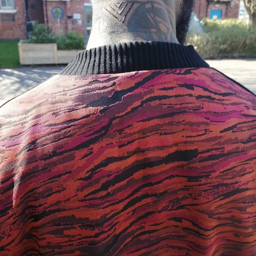 Back of garment with black collar and red, pink, black pattern