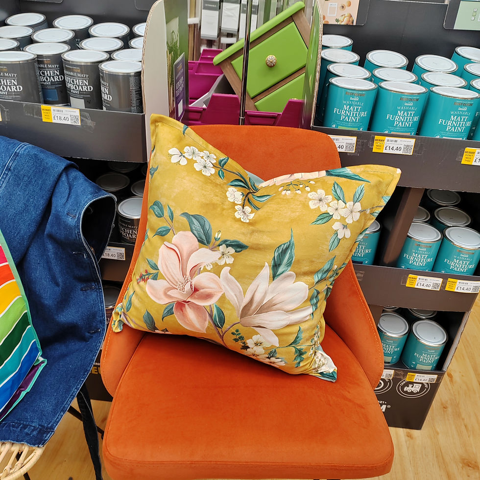 Yellow floral pillow on an orange chair