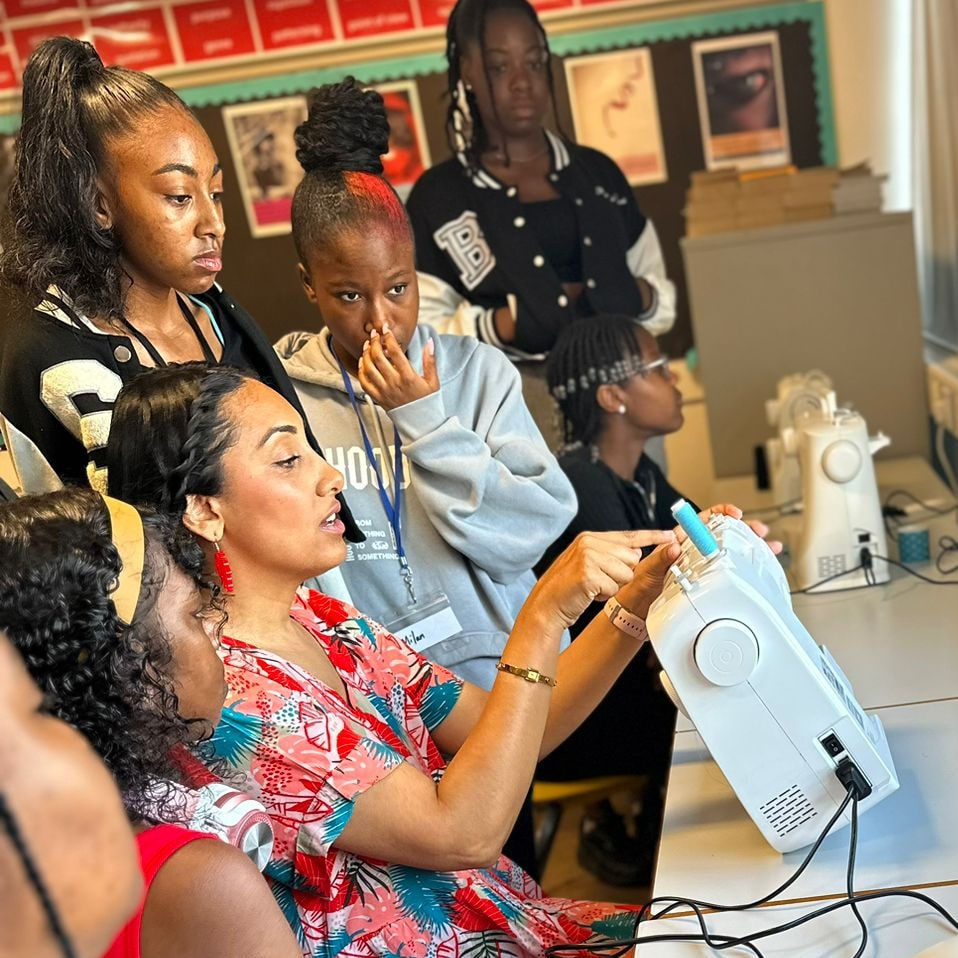 Instructor teaching young women in local sewing classes for beginners
