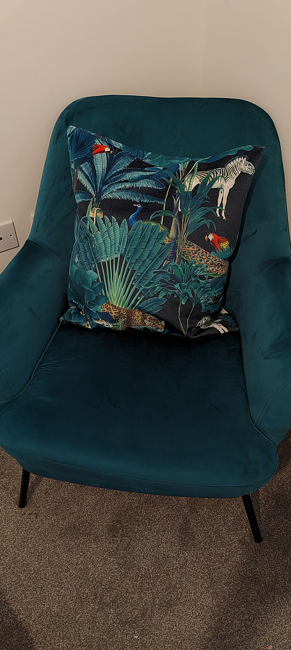 Teal armchair with a decorative patterned cushion
