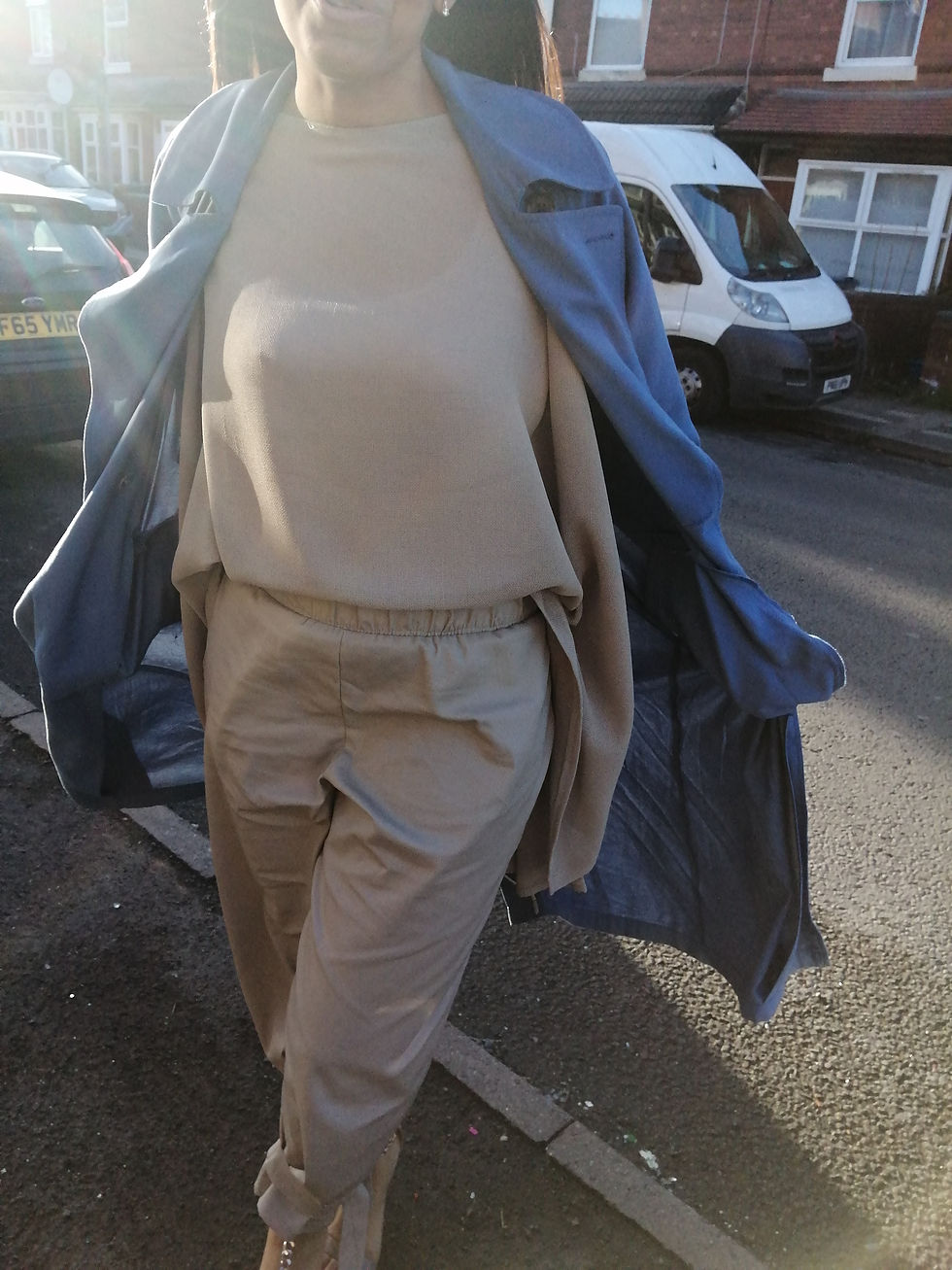 Person walking on street in blue coat and beige outfit