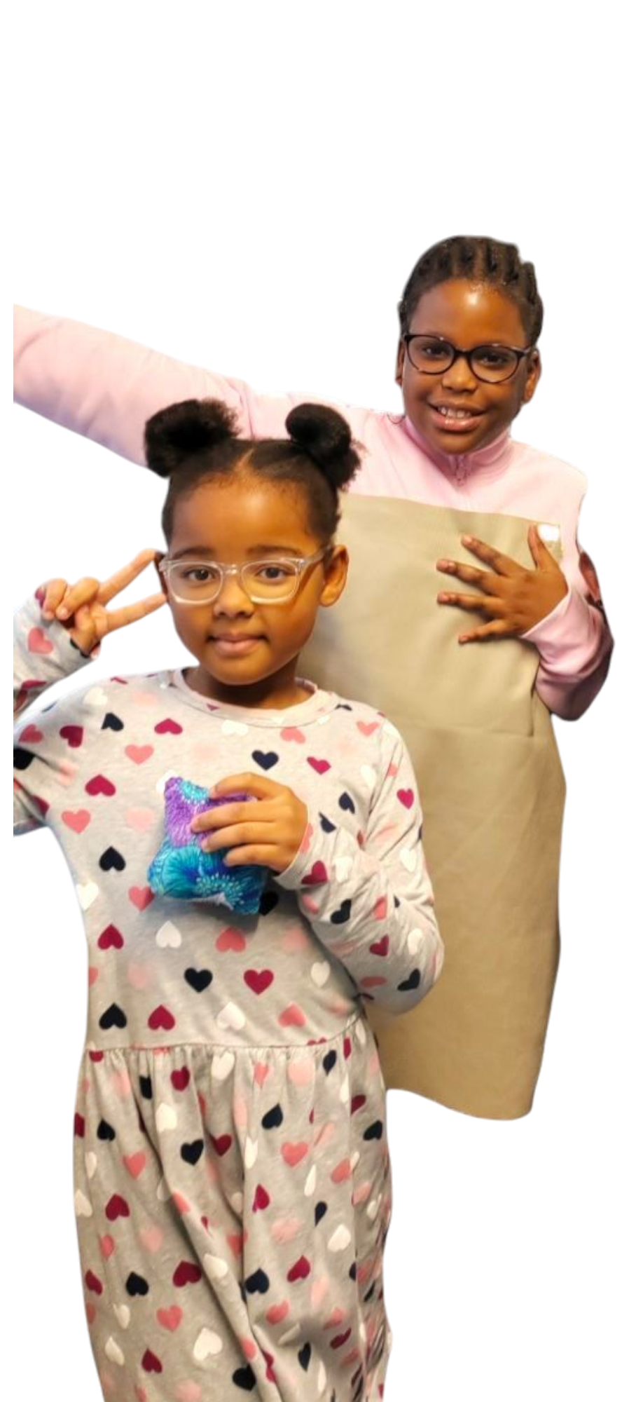 Young girls smiling, one with a colorful craft from sewing classes