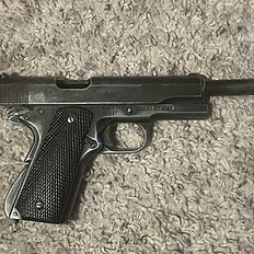 Black semi-automatic handgun on a textured carpet