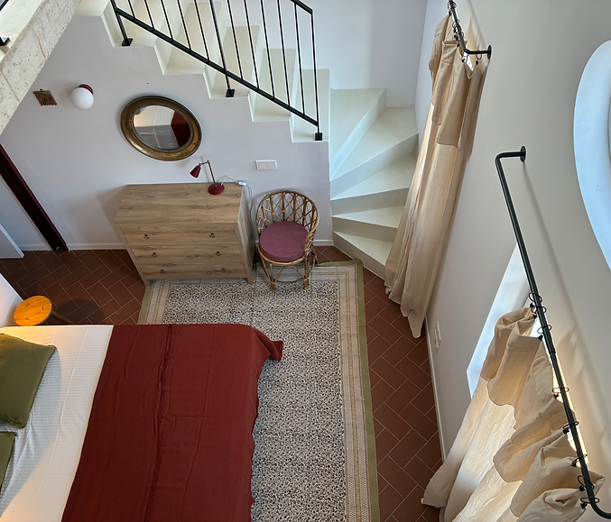 dormitorio princiapl en beige verde y burdeos con cortinas gasa algodon espejo envejecido comoda de madera y silla de ratan con cojin burdeos cortinas rusticas gasa con barra cortinas rustica en curva vivienda Mahón Menorca
