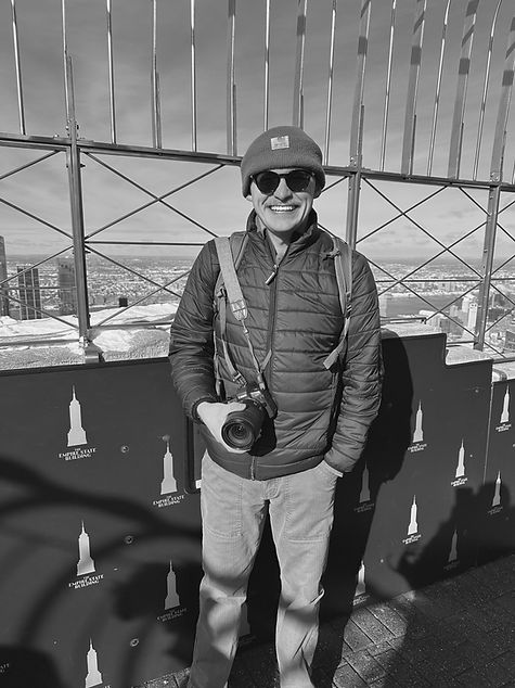 man poses with video camera at the top of the Empire State Building