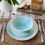 Thumbnail: turquoise hand thrown porcelain dinner service place setting for one on rustic table top
