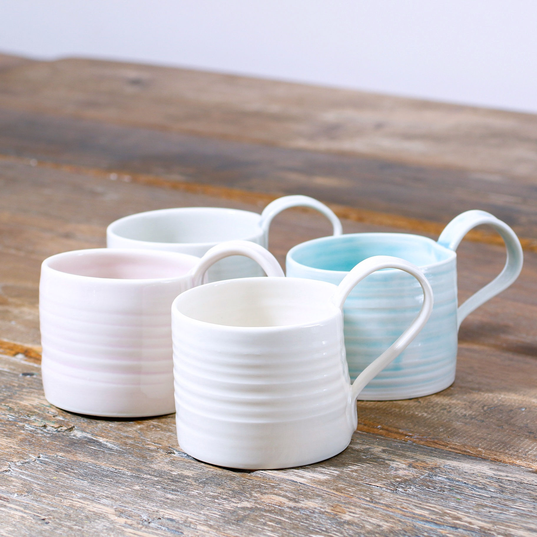 group of small hand thrown porcelain coffee cup side view