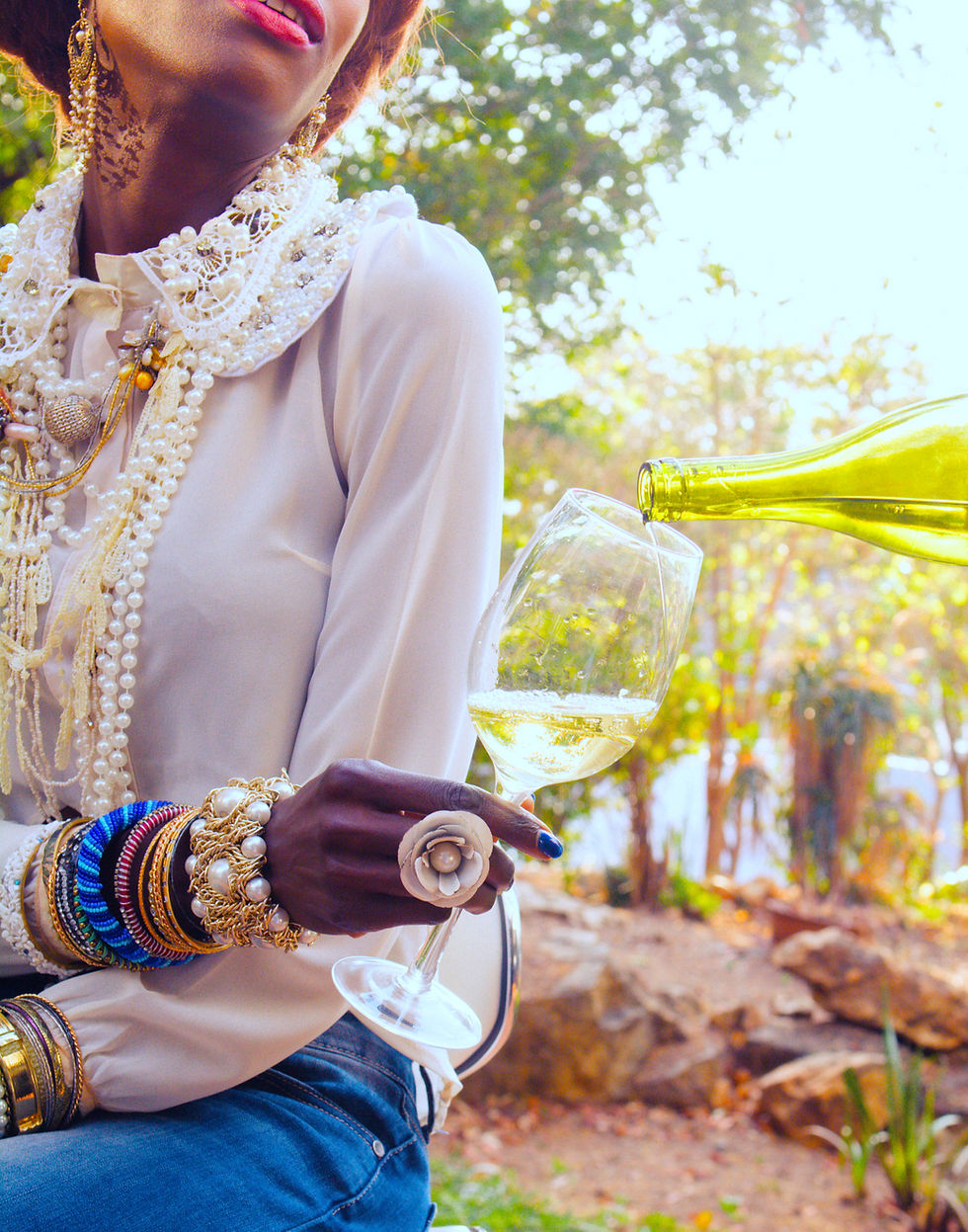 White wine being poured into an elegant crystal glass during an intimate outdoor gathering, celebrating hospitality, wine culture and the art of gathering.