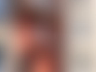 Façade d'immeuble beige et rouge avec balcons en métal noir. Porte noire en bas. Fenêtres rectangulaires. Ambiance tranquille. Immeuble sans syndic de copropriété