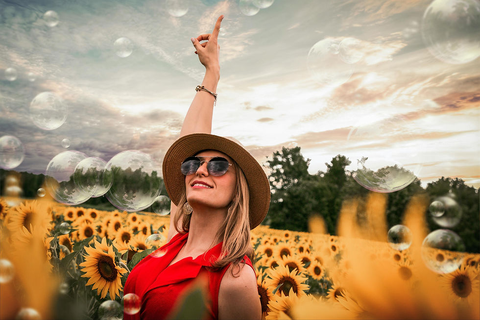 Woman standing in a field of sunflowers and bubbles