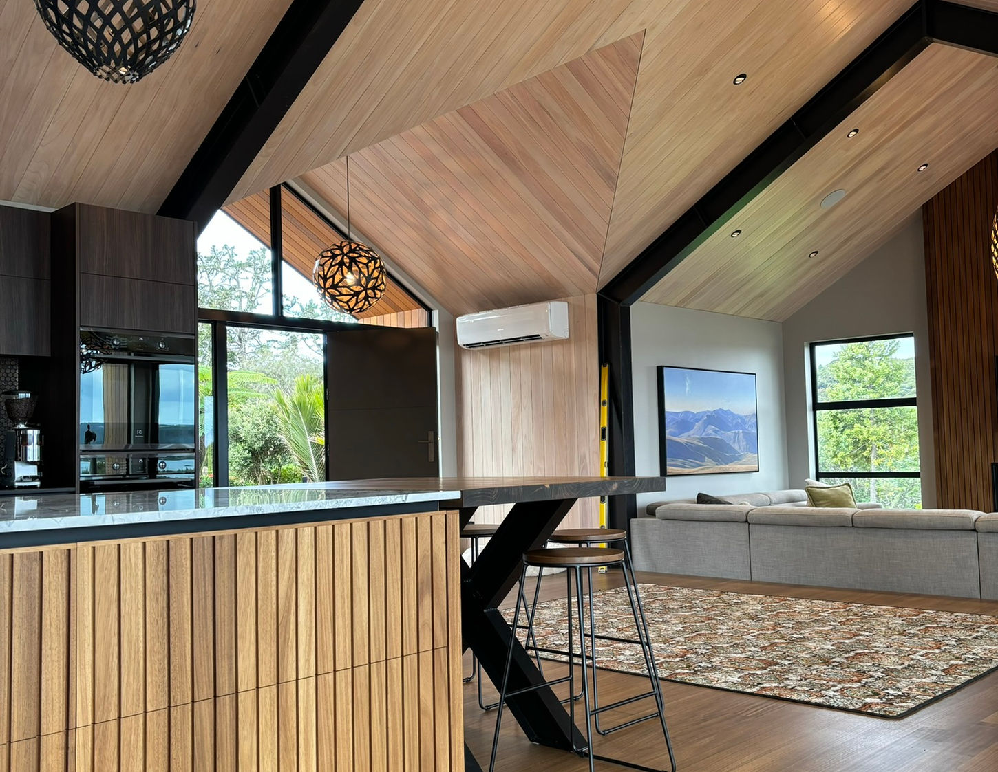 Modern kitchen design with wood cabinetry and high ceilings