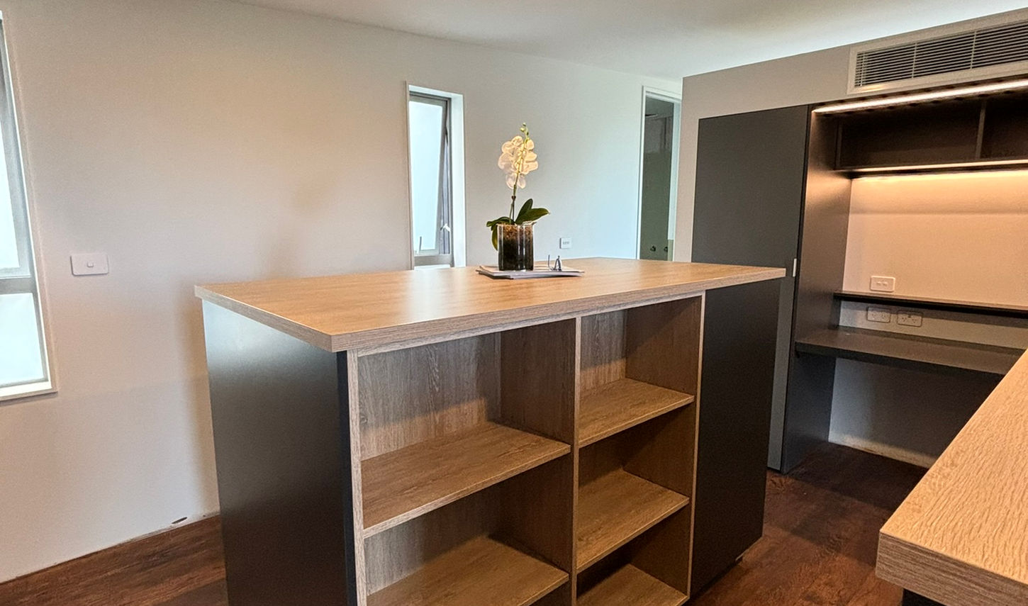 Modern wardrobe island with open shelving and dark cabinetry