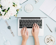 Flat lay home office desk. Women workspace with female hands, laptop, white peony flowers 