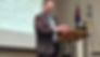 Joel standing behind a podium teaching
