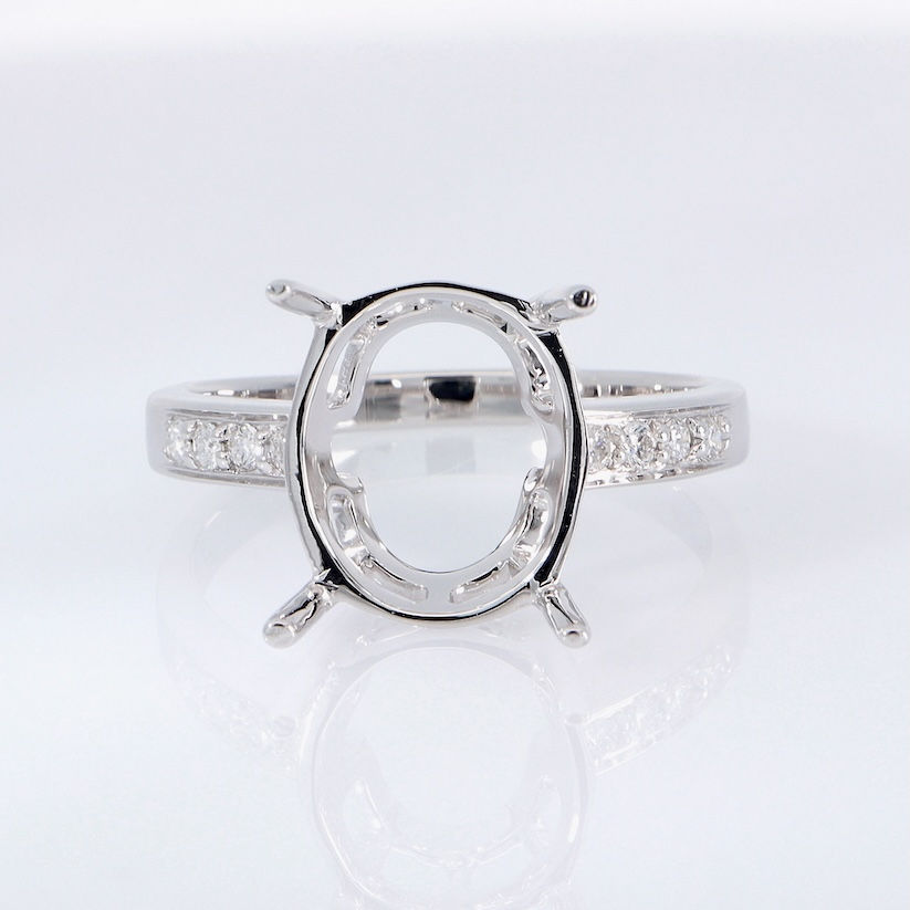 Classic oval diamond engagement ring setting with a pavé diamond band in fine gold.