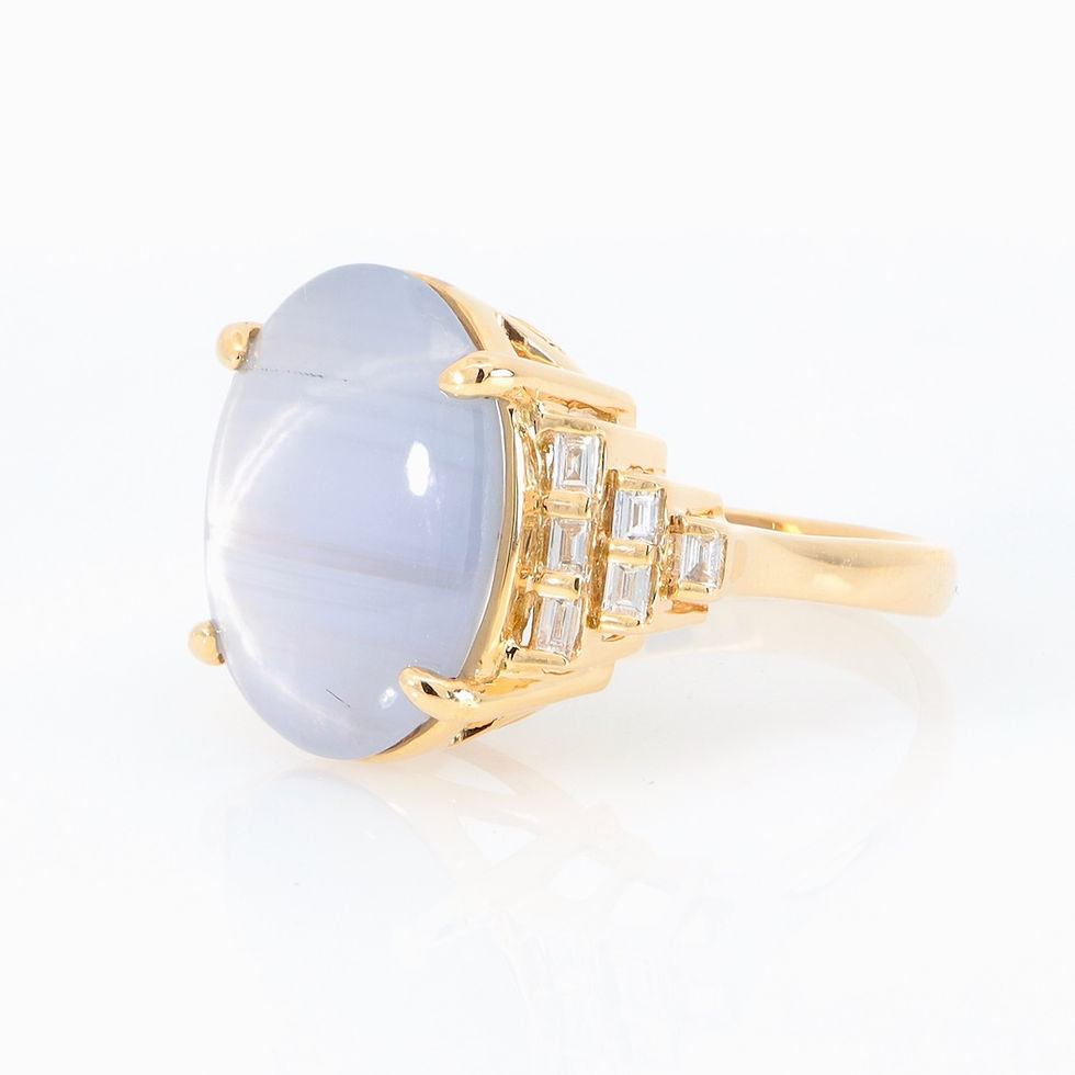 Thumbnail: Art Deco gemstone jewelry ring with an oval star gemstone and tiered baguette diamonds in gold.
