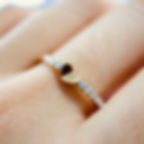 Minimalist heart diamond ring with a polished gold heart on a pavé diamond band.