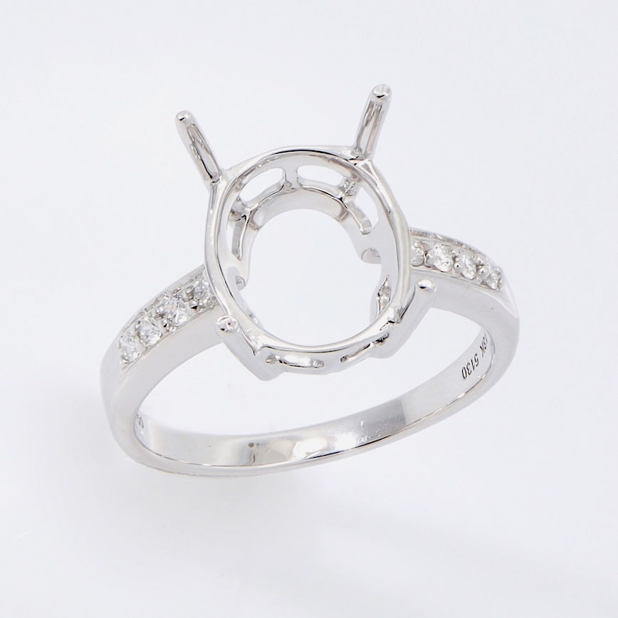 Classic oval diamond engagement ring setting with a pavé diamond band in fine gold.