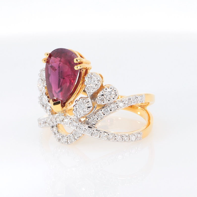 Thumbnail: Regal crown gemstone ring with a pear-shaped gemstone and intricate diamond details in fine gold.