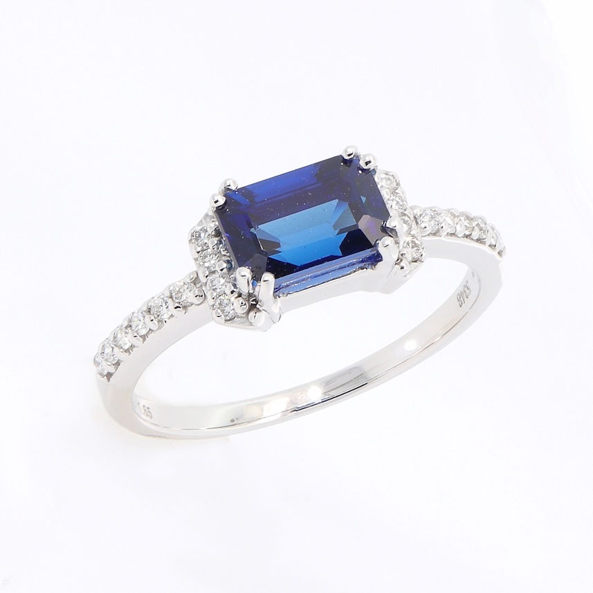 Thumbnail: Emerald-cut gemstone ring with a partial diamond halo on a pavé diamond gold band.