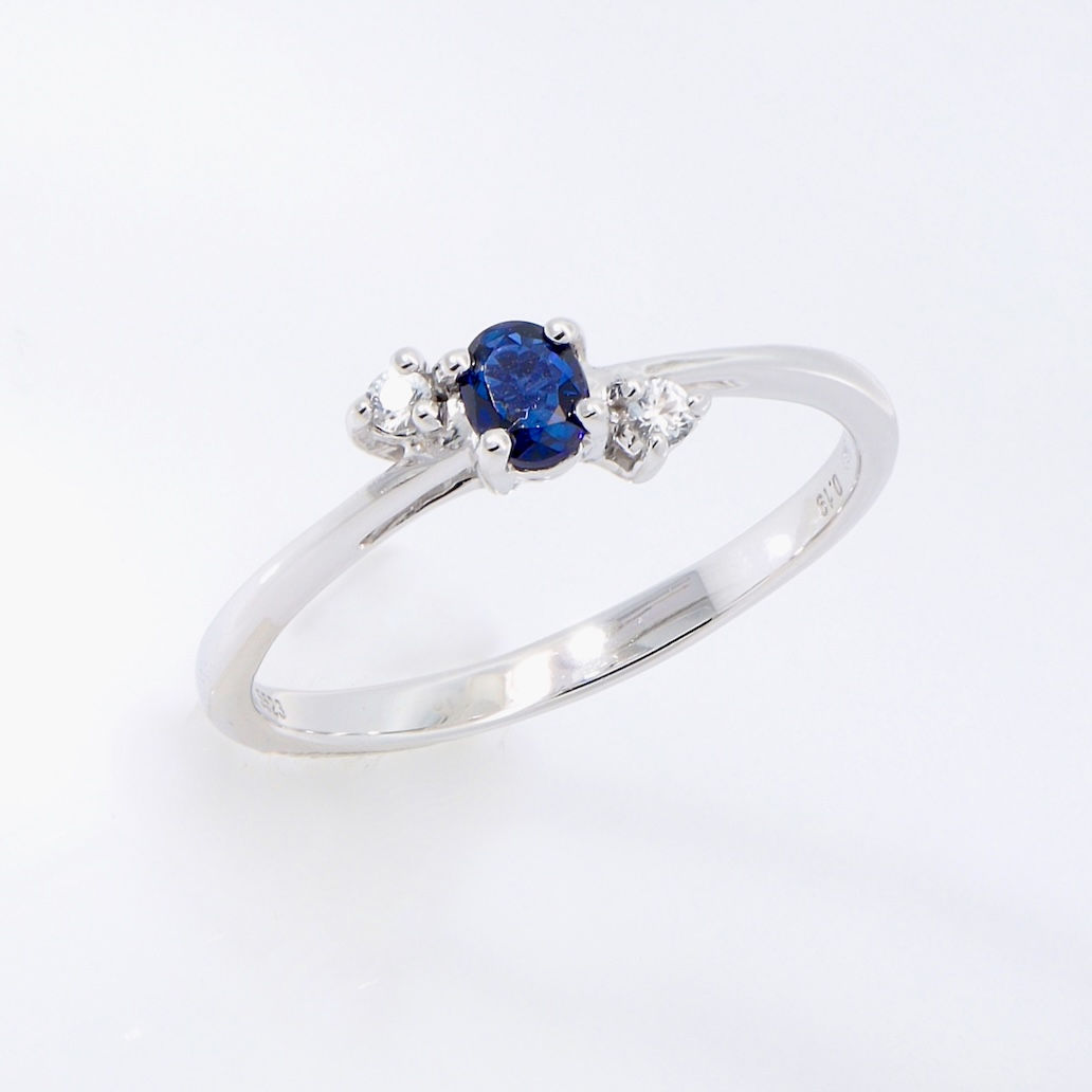 Three-stone oval blue sapphire ring with diamond accents